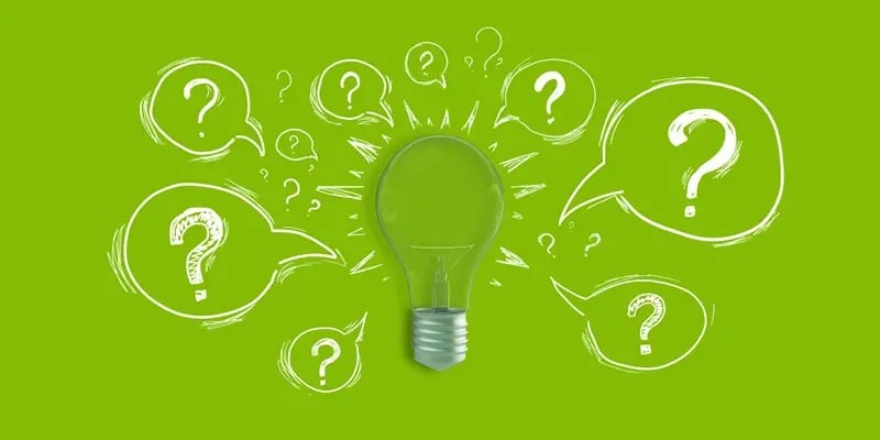 light bulb on green backgroundwith question marks