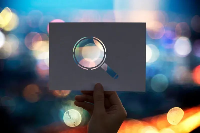 magnifying glass held against a background bokeh