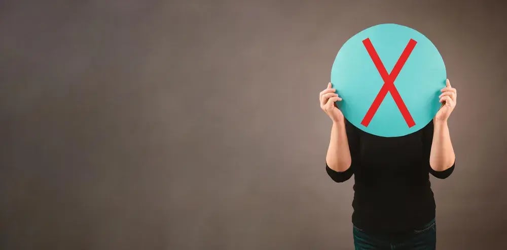 person holding an X sign over their face