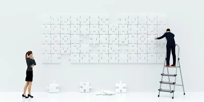 two businesspeople building a puzzle
